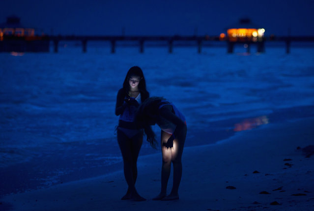 Girls walk with their cell phones along the beach at twilight during the Labour Day long weekend in Ft Myers Beach, Florida August 31, 2014. (Photo by Carlo Allegri/Reuters)