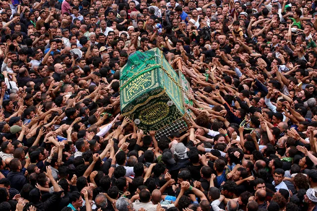 Iraqi Shiite Muslim worshipers carry the symbolic coffin of the 8th century Imam Musa al-Kadhim during the funeral processions on the anniversary of his death at his shrine in Baghdad's northern district of Kadhimiya on April 23, 2017. (Photo by Sabah Arar/AFP Photo)