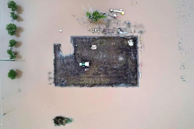 A tractor rests on a small paddock surrounded by floodwater on March 07, 2022 in Brisbane, Australia. Residents of northern New South Wales are still cleaning up following unprecedented storms and the worst flooding in a decade. (Photo by Dan Peled/Getty Images)