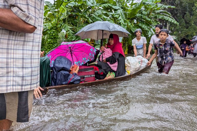 People wade through flood waters in Feni on August 22, 2024. Floods triggered by torrential rains have swamped a swath of low-lying Bangladesh, disaster officials said on August 22, adding to the new government's challenges after weeks of political turmoil. (Photo by Zakir Hossain Chowdhury/AFP Photo)