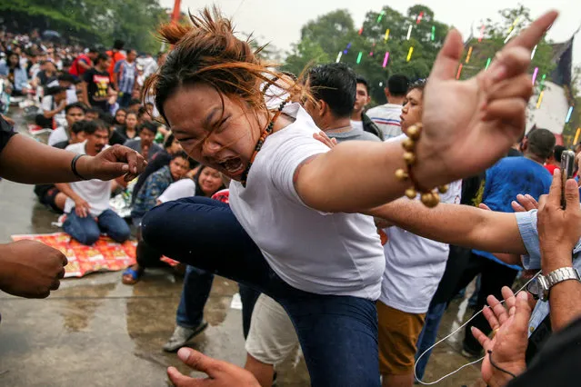 A devotee in trance mimics a beast during a religious tattoo festival at Wat Bang Phra monastery, where devotees believe that their tattoos have mystical powers, in Nakhon Pathom province, Thailand, March 16, 2019. (Photo by Athit Perawongmetha/Reuters)