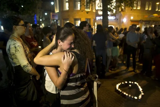 Teenagers comfort each other during a candlelight vigil in Jerusalem for Shira Banki, who died on Sunday of stab wounds sustained when an ultra-Orthodox man with a knife attacked a Gay Pride parade in Jerusalem three days ago, August 2, 2015. High school student Banki, 16, was one of six people wounded in the assault. Her death highlighted the city's sharp social divisions between Orthodox and secular Jews. (Photo by Ronen Zvulun/Reuters)