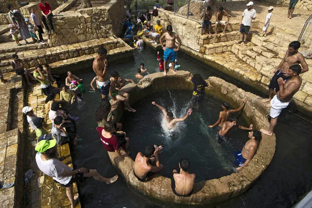 Israelis and Palestinians cool themselves off at the Ein Fuar spring located in the West Bank, Judean Desert near Jericho, 05 August 2015. Temperatures in parts of Israel and Palestine rose to 45 degrees Celsius as a heat wave visits the region. (Photo by Abir Sultan/EPA)