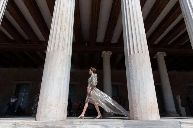 A model presents a creation of Greek fashion designer Vassilios Kostetsos at the Stoa of Attalos in ancient Agora of Athens, Greece, on May 23, 2022. (Photo by Marios Lolos/Xinhua/Alamy Live News)