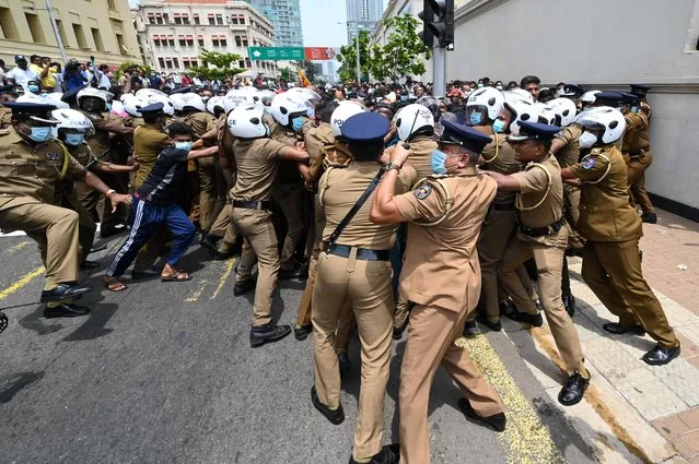 Government supporters and police clash outside the President's office in Colombo on May 9, 2022. (Photo by Ishara S. Kodikara/AFP Photo)