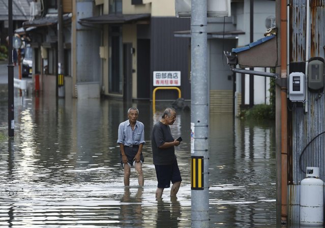 People wade through a flooded street as the city was hit by heavy rain in Ogaki, central Japan, Saturday, August 31, 2024, following a tropical storm in the area. (Photo by Natsumi Yasumoto/Kyodo News via AP Photo)