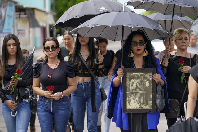 Mourners arrive to the funeral of armed civilian defense leader Hipolito Mora and two of his bodyguards at his home in La Ruana, Mexico, Saturday, July 1, 2023. Mora, the leader of an armed civilian movement that once drove a drug cartel out of the western state of Michoacan, was killed on June 29th on a street in his hometown. (Photo by Eduardo Verdugo/AP Photo)