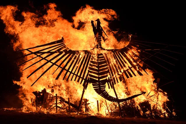 A bonfire featuring a large wooden phoenix burns at the Glastonbury Festival of Music and Performing Arts on Worthy Farm near the village of Pilton in Somerset, South West England, on June 21, 2017. (Photo by Oli Scarff/AFP Photo)