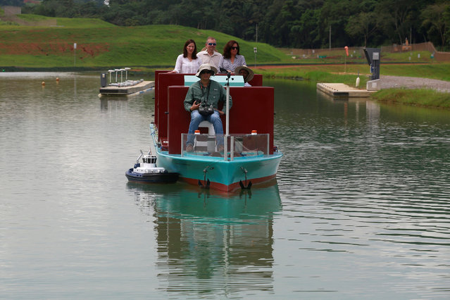 A Panama Canal pilot maneuvers a miniature tugboat as he sits on a scale cargo boat during a training day at the scale model maneuvering training facility of the Panama Canal, a day before the inauguration of the Panama Canal Expansion project on the outskirts of Panama City, in Panama June 25, 2016. (Photo by Alberto Solis/Reuters)