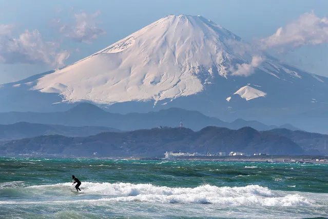A local surfer is seen with Mount Fuji in the background from the beach of Enoshima during the build up to the Tokyo 2020 Olympic Games on January 30, 2020 in Fujisawa, Kanagawa Prefecture, Japan. The venue will hold the sailing events. (Photo by Clive Rose/Getty Images)