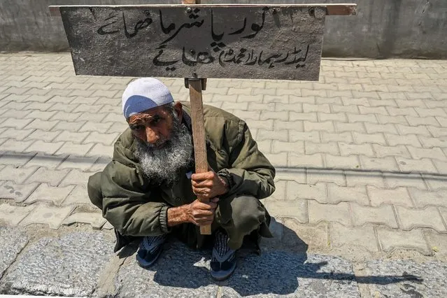 A man holds a placard during a protest in Srinagar on June 10, 2022. A spontaneous strike was observed in Srinagar to protest against former India's Bharatiya Janata Party spokeswoman Nupur Sharma over her remarks about Prophet Mohammed, which sparked outrage from the Islamic world and a diplomatic furore. (Photo by Tauseef Mustafa/AFP Photo)