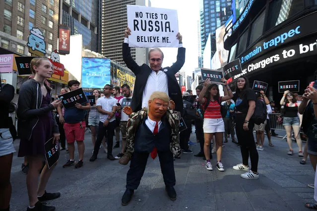 A participant dressed as both Russia's President Vladimir Putin and President Donald Trump attends a protest against Trump's announcement that he plans to reinstate a ban on transgender individuals from serving in any capacity in the U.S. military, in Times Square, in New York City, New York on July 26, 2017. (Photo by Carlo Allegri/Reuters)