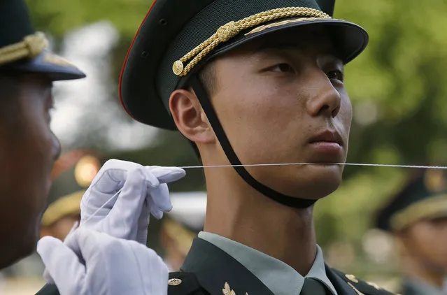 An officer of the Chinese People's Liberation Army uses a string to ensure that soldiers stand in a straight line before a  welcoming ceremony in Beijing. (Photo by Kim Kyung-Hoon/Reuters)