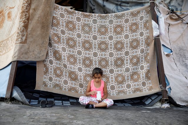 A displaced child plays in front of her family's makeshift shelter, amid hostilities between Hezbollah and Israeli forces, in Beirut, Lebanon on October 16, 2024. (Photo by Louisa Gouliamaki/Reuters)