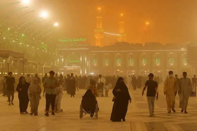 People are pictured near Imam Hussein shrine during a sandstorm in the holy city of Kerbala, Iraq, June 26, 2022. (Photo by Abdullah Dhiaa Al-deen/Reuters)