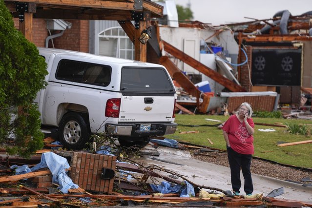 A women stands outside a damaged home after a tornado hit the area in Oklahoma City, Sunday, November 3, 2024. (Photo by Bryan Terry/The Oklahoman via AP Photo)