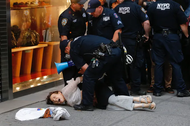 A woman is arrested by police near Trump Tower during a protest against US President Donald Trump August 14, 2017 in New York. While on his first trip back to Trump Tower since his inauguration, marchers came together to protest against white supremacy and hatred and against Trump's to meet ongoing threats from North Korea with “fire and fury”. (Photo by Eduardo Munoz Alvarez/AFP Photo)