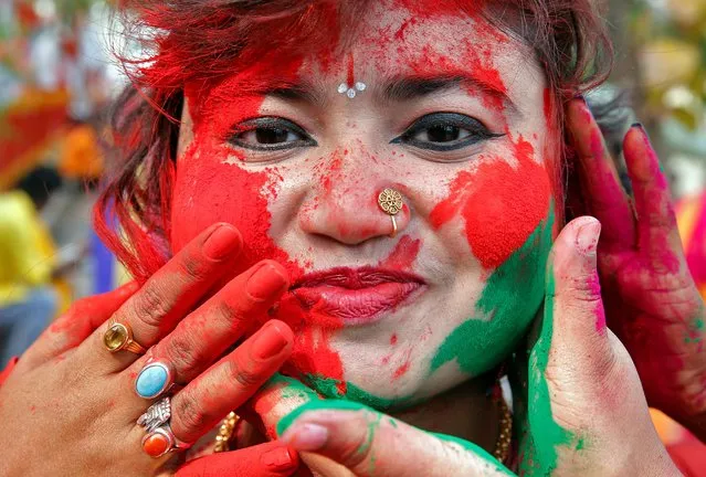 A student of Rabindra Bharati University reacts as fellow students apply colored powder to her face during Holi celebrations inside the university campus in Kolkata, India, March 5, 2020. (Photo by Rupak De Chowdhuri/Reuters)