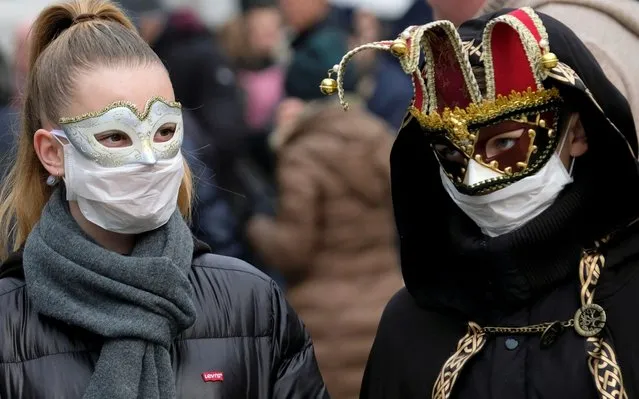 Masked carnival revellers wear protective face masks at Venice Carnival, which the last two days of, as well as Sunday night's festivities, have been cancelled because of an outbreak of coronavirus, in Venice, Italy on February 23, 2020. (Photo by Manuel Silvestri/Reuters)