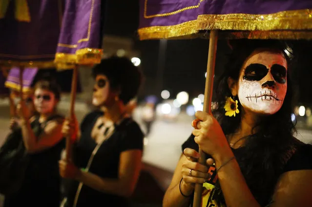Women's activists march for pro-choice rights past street art displayed on a wall on September 28, 2017 in Rio de Janeiro, Brazil. Brazilian law currently only allows abortion in cases of rape, incest, or dire health threats endangering the life of the mother. A new U.N. study shows only one in four abortions are safe in Latin America- which generally has strict abortion laws. (Photo by Mario Tama/Getty Images)