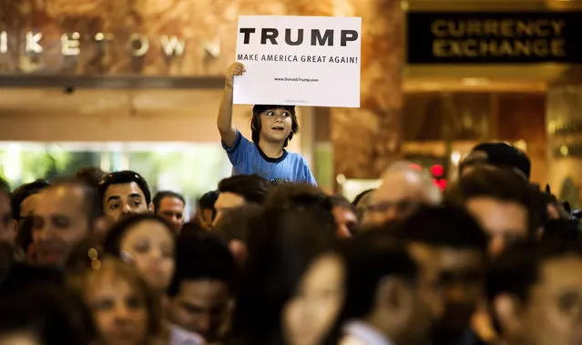 A boy holds up a sign as US presidential candidate Donald Trump speaks a press conference in the lobby of Trump Tower in New York, New York, USA, 03 September 2015. (Photo by Justin Lane/EPA)