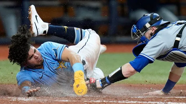 Tampa Bay Rays' Jonathan Aranda, left, scores ahead of the tag by Toronto Blue Jays catcher Danny Jansen on a two-run double by Wander Franco during the fourth inning of a baseball game Thursday, September 22, 2022, in St. Petersburg, Fla. (Photo by Chris O'Meara/AP Photo)