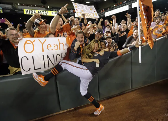 Baltimore Orioles center fielder Adam Jones celebrates with fans after a baseball game against the Toronto Blue Jays, Tuesday, September 16, 2014, in Baltimore. Baltimore won 8-2 to clinch the American League East. (Photo by Patrick Semansky/AP Photo)