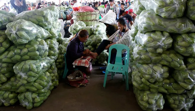 A vegetable vendor gets a pedicure between bags of Chayotes at a vegetable market in La Trinidad, Benguet in northern Philippines August 6, 2016. (Photo by Erik De Castro/Reuters)