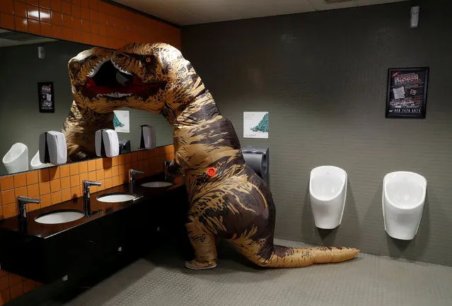 A visitor wearing a T-Rex costume uses the lavatory at the London Comic Con, at the ExCel exhibition centre in east London, Britain on October 27, 2017. (Photo by Peter Nicholls/Reuters)
