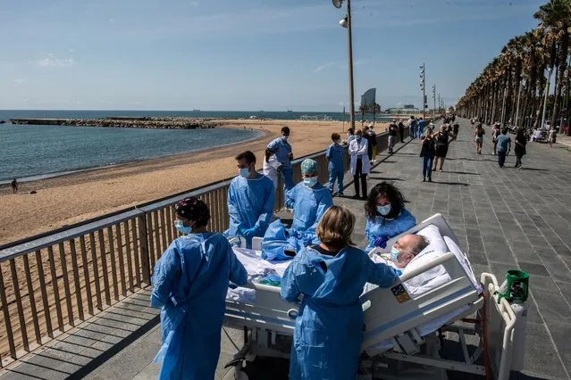 Hospital patient Isidre Correa is taken to the seaside by intensive health care staff outside the Hospital del Mar on June 03, 2020 in Barcelona, Spain. Mr Correa was taken into Intensive Care on April 14 after his coronavirus infection worsened while he had been in hospital since April 9. Today he will leave the ICU to follow his recovery at the hospital. Hospital del Mar is taking recovering COVID-19 patients from the ICU to the seaside as part of their recovering process aiming to humanize its Intensive Care Units. (Photo by David Ramos/Getty Images)
