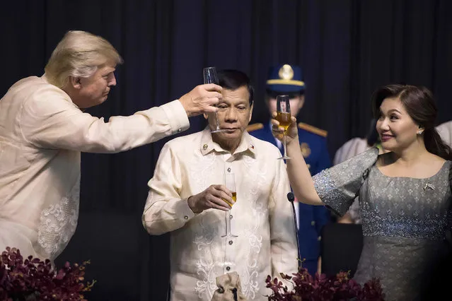 Philippine President Rodrigo Duterte (C) stands as his partner Honeylet Avancena (R) toasts US President Donald Trump during a special gala celebration dinner for the Association of Southeast Asian Nations (ASEAN) in Manila on November 12, 2017. World leaders arrive in the Philippines' capital for two days of summits beginning on November 13. (Photo by Jim Watson/AFP Photo)