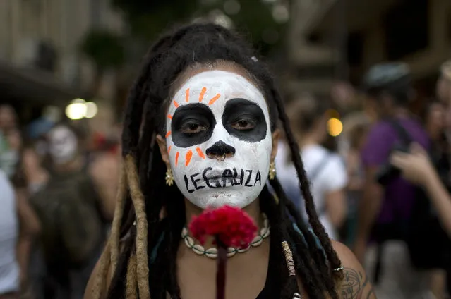 In this Monday, November 13, 2017 photo, a woman with the word “Legalize” painted across her mouth marches against a recent congressional committee vote to make abortion illegal without exception nationwide, in Rio de Janeiro, Brazil. Abortion is currently allowed in cases of rape, a pregnancy that threatens a woman's life or a fetus with anencephaly, but the committee adopted a measure that would remove those exceptions. (Photo by Silvia Izquierdo/AP Photo)