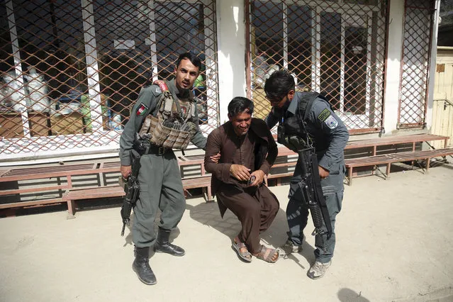 Afghan policemen comfort a man after an attack on a maternity hospital, in Kabul, Afghanistan, Tuesday, May 12, 2020. Militants stormed a maternity hospital in the western part of Kabul on Tuesday, setting off an hours-long shootout with the police and killing over a dozen people, including two newborn babies, their mothers and an unspecified number of nurses (Photo by Rahmat Gul/AP Photo)