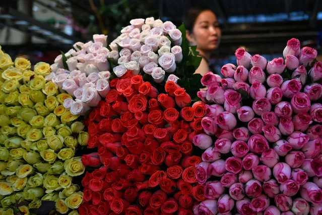 A flower seller waits for customers at the Quang Ba flower market in Hanoi on May 11, 2020. (Photo by Manan Vatsyayana/AFP Photo)
