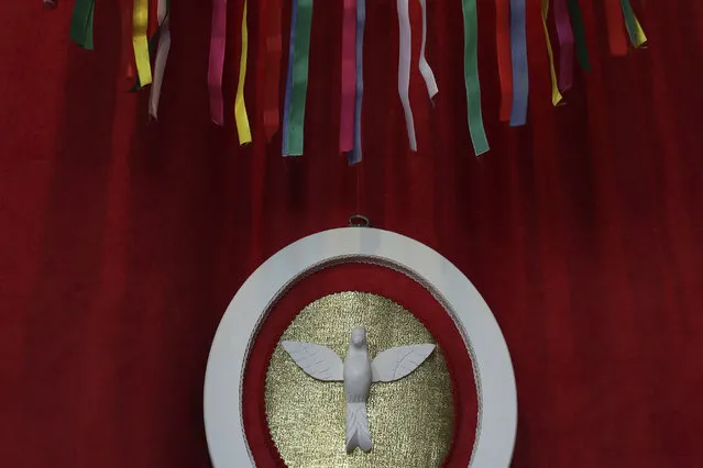 In this November 9, 2017 photo, a symbol of the Holy Spirit decorates the altar inside the House of Azorean Culture, during the Azorean Culture Festival which celebrates the culture of the Azores, the Portuguese island chain that lies in the mid-Atlantic, in Enseada de Brito, in Brazil's Santa Catarina southern state. At the climax of the festival, a parade leads to a Mass at Our Lady of the Rosary Church. (Photo by Eraldo Peres/AP Photo)