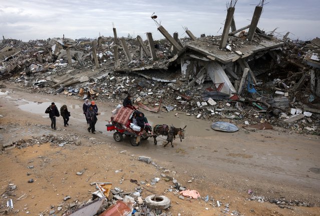 Palestinians use a donkey-pulled cart to transport their belongings as they flee Beit Lahia in the Northern Gaza Strip on March 21, 2025. Gaza's civil defence agency said on March 20 that 504 people had been killed since the bombardment resumed, more than 190 of them minors. (Photo by Bashar Taleb/AFP Photo)