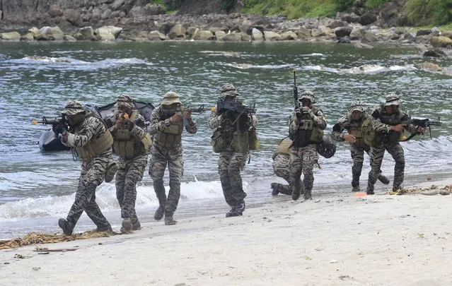 Members of the Naval Special Operations Group, an elite unit of the Philippine Marines, take their positions as they move out to rescue hostages from mock rebels during the Fleet-Marine Amphibious Exercise at the marine headquarter in Ternate, cavite city, south of Manila September 24, 2015. (Photo by Romeo Ranoco/Reuters)