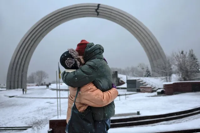 A couple embrace in the snow at The Arch of Freedom of the Ukrainian people on November 27, 2022 in Kyiv, Ukraine. In recent days, Russia has retreated from the Ukrainian city of Kherson, allowing Ukraine to reclaim swaths of nearby territory occupied since shortly after the Russian invasion on February 24, 2022. (Photo by Jeff J. Mitchell/Getty Images)
