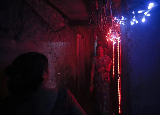 People walk in a slum's alley illuminated by colorful lights ahead of Diwali, the Hindu festival of lights, in Mumbai November 12, 2012. (Photo by Danish Siddiqui/Reuters)