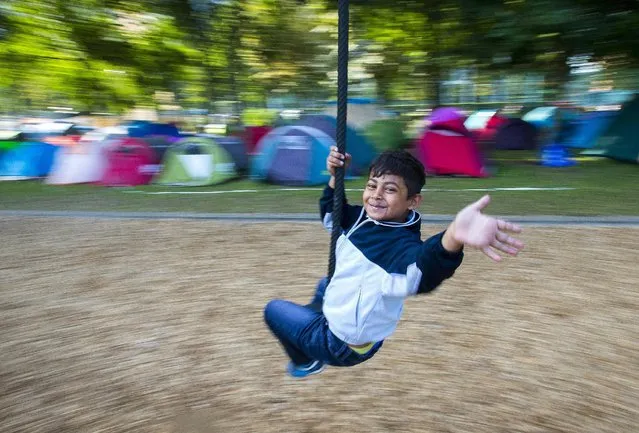A young migrant plays on a swing at a makeshift camp outside the foreign office in Brussels, Belgium, September 9, 2015. (Photo by Yves Herman/Reuters)