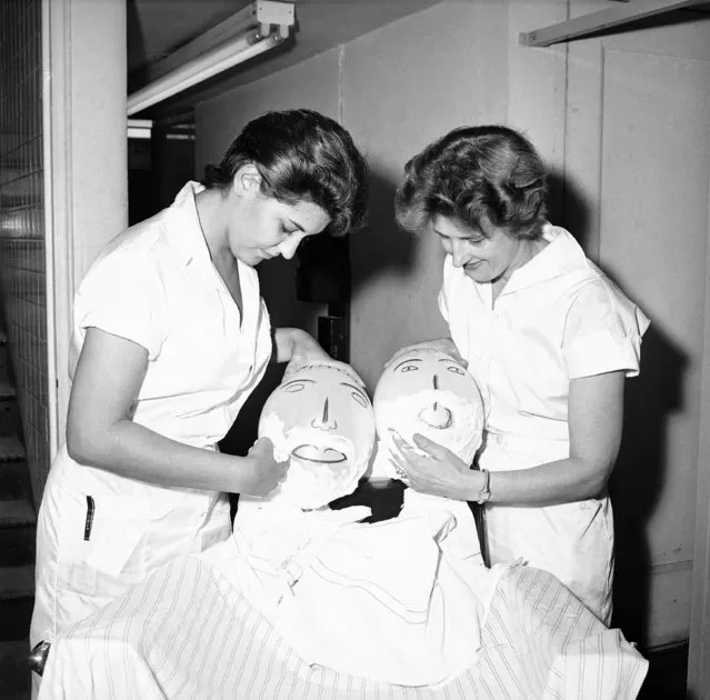 Rosanna Lambert, left and Hrefna Olafsdottir, lather balloon heads at the New York Barber School in New York October 8, 1959. The balloons are used for beginners practicing with a straight edge razor. Miss Lambert is from New York and  Miss Olafsdottir is from Reykjavik, Iceland. (Photo by Robert Kradin/AP Photo)