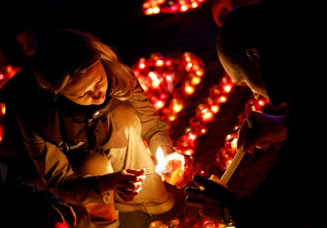 People light candles during a vigil in memory of the victims of a shooting attack at the Crocus City Hall concert venue outside Moscow, in Donetsk, Russian-controlled Ukraine, on March 24, 2024. (Photo by Alexander Ermochenko/Reuters)
