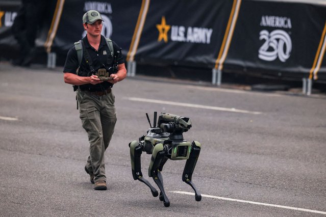 A participant in tactical gear controls a quadrupedal robot on June 14, 2025. (Photo by Carlos Barria/Reuters)