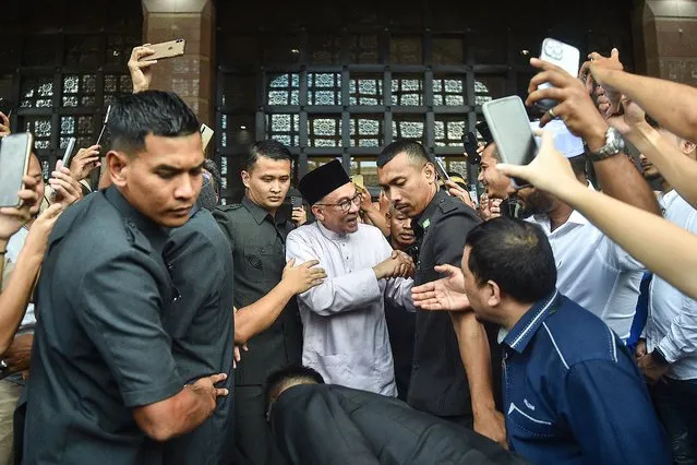 Malaysia's Prime Minister Anwar Ibrahim greets people as he leaves Putra Mosque after prayers in Putrajaya, on November 25, 2020. (Photo by Arif Kartono/AFP Photo)