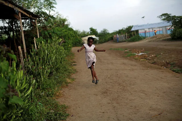 A deaf girl runs and jumps in Leveque, Haiti, June 26, 2016. (Photo by Andres Martinez Casares/Reuters)