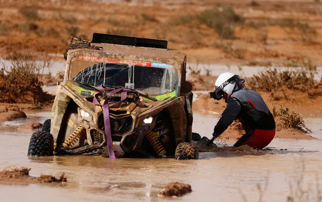 Speed Team’s Joan Font and co-driver Themis Lopez attempt to retrieve their vehicle after it was stuck in water during stage 9 of Dakar Rally in Saudi Arabia on January 10, 2023. (Photo by Hamad I Mohammed/Reuters)