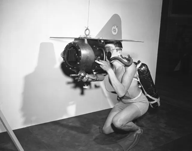 Gerald E. Darrab, Ph2, U.S.N., demonstrates the completely mobile 35 mm under-water motion picture camera which will be used by the U.S. Navy. It was at the U.S. Naval Photographic center Anacostia, Washington on October 31, 1950. The camera will make the diver-photographer entirely independent on surface assistance and is designed so that it can be completely operated from the outside of the housing. External controls are provided for the lens diaphragm, focus, and starting switch. The unit has detachable wings and vertical rudder which aid in transporting and stabilizing the camera under-water. (Photo by Bill Allen/AP Photo)