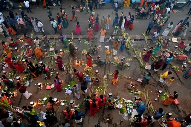 Hindu women cook rice dish along a street during a ceremony at the Dharavi slum to celebrate Hindu harvest festival of Pongal, in Mumbai on January 15, 2023. (Photo by Indranil Mukherjee/AFP Photo)