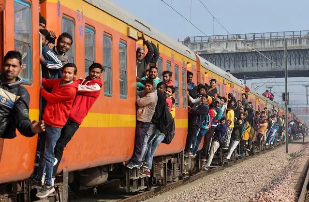 Commuters travel in an overcrowded train near a railway station in Ghaziabad, on the outskirts of New Delhi, India on February 1, 2023. (Photo by Anushree Fadnavis/Reuters)