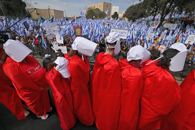 Israeli protesters wearing “Handmaid's Tale” costumes attend a rally outside the Knesset (parliament) in Jerusalem on February 13, 2023, against controversial legal reforms being touted by the country's hard-right government. (Photo by Ahmad Gharabli/AFP Photo)
